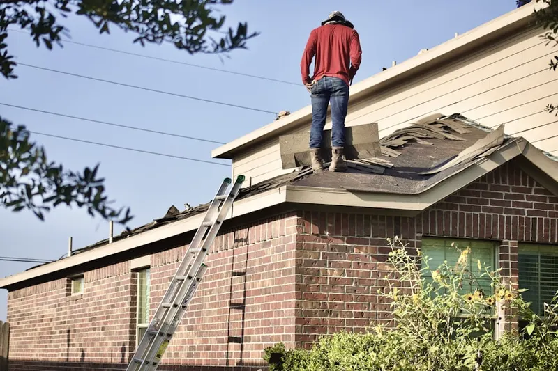Professional roofer working on a residential roof in Albany Park
